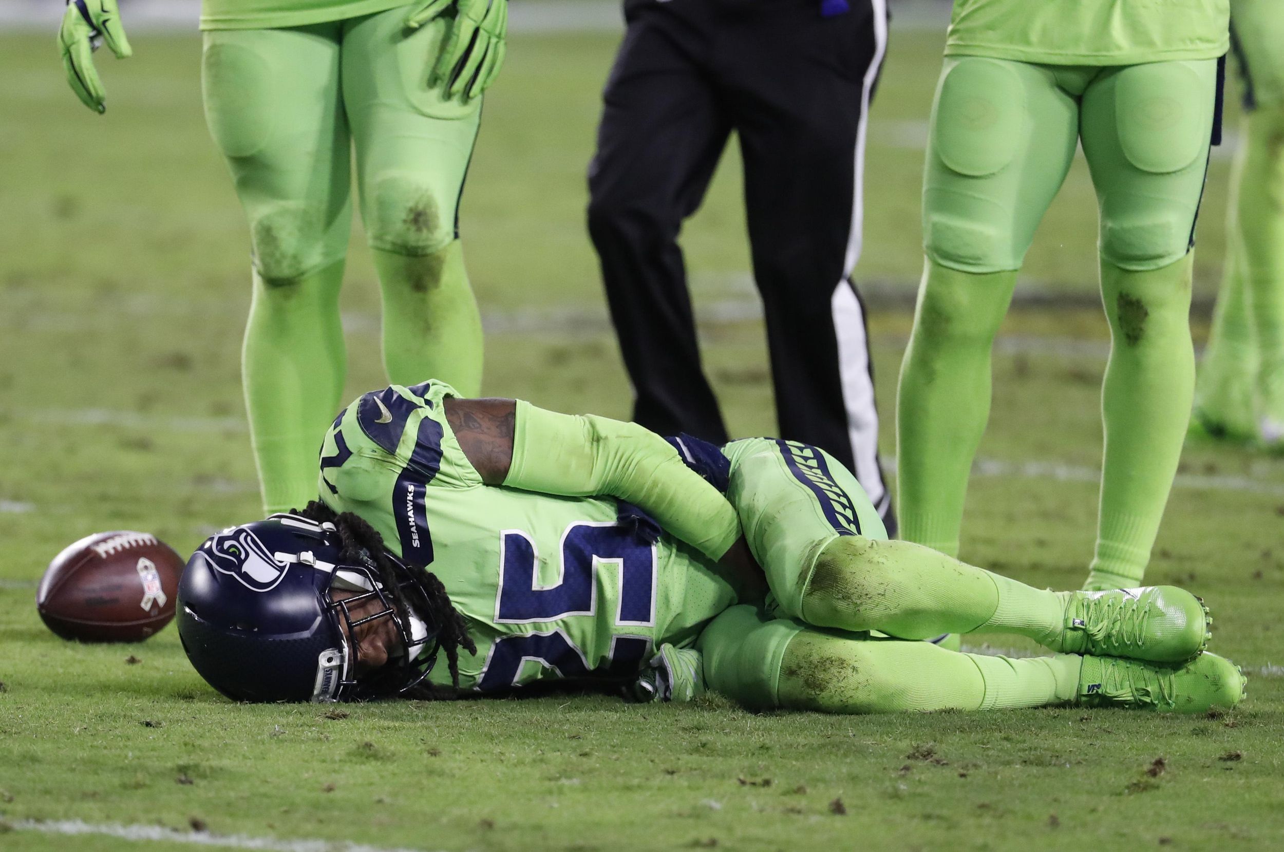 Seattle Seahawks cornerback Richard Sherman lies on the turf after suffering a torn Achilles tendon in Thursday night’s game against Arizona. (Rick Scuteri / Associated Press)