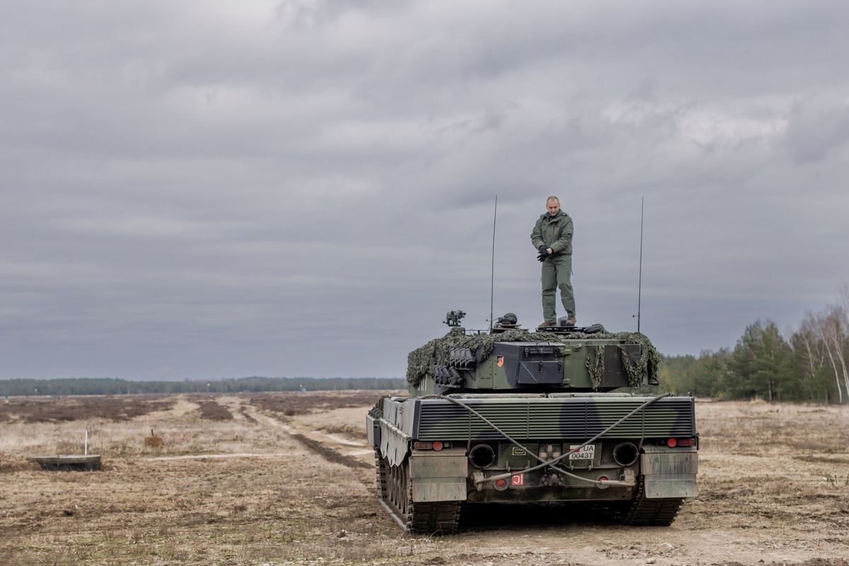A soldier stands on top of a Leopard 2 tank operated by Ukrainian soldiers during a demonstration at a military base in Swietoszow, Poland, on Feb. 13.  (New York Times)