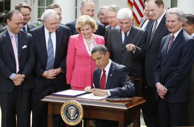 Lawmakers look on as President Barack Obama signs the Credit Card Accountability, Responsibility and Disclosure Act Friday in the Rose Garden  at the White House. The new rules will take effect by February 2010.  (Associated Press / The Spokesman-Review)