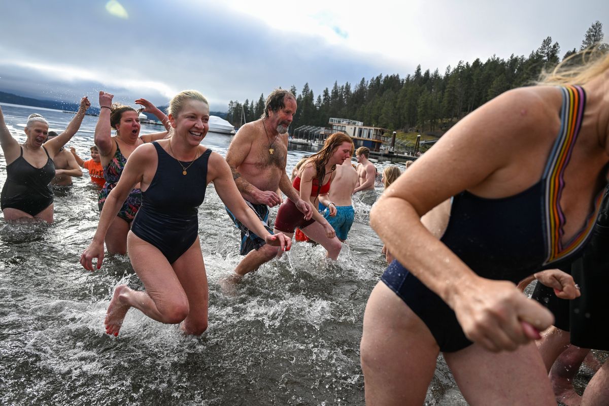 Thoroughly chilled members of the large crowd that waded into Lake Coeur d’Alene returns to Sanders Beach squealing in shock Monday at the annual Polar Bear Plunge, a decades-old tradition on the first day of the new year in Coeur d’Alene.  (Jesse Tinsley/THE SPOKESMAN-REVIEW)