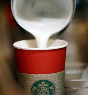 A barista pours steamed milk into a red paper cup while making an espresso drink at a Starbucks coffee shop in the Pike Place Market, Tuesday, in Seattle. It's as red as Santa's suit, a poinsettia blossom or a loud Christmas sweater. Yet Starbucks' minimalist new holiday coffee cup has set off complaints that the chain is making war on Christmas. (AP Photo/Elaine Thompson)