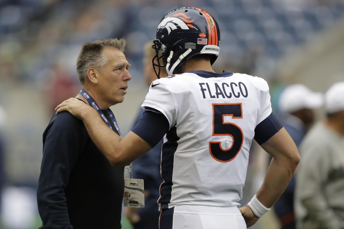 Jim Zorn, left, the coach and general manager of the XFL’s Seattle Dragons, talks with Denver Broncos quarterback Joe Flacco before an NFL preseason game against the Seattle Seahawks on Aug. 8 at CenturyLink Field. (Stephen Brashear / Associated Press)