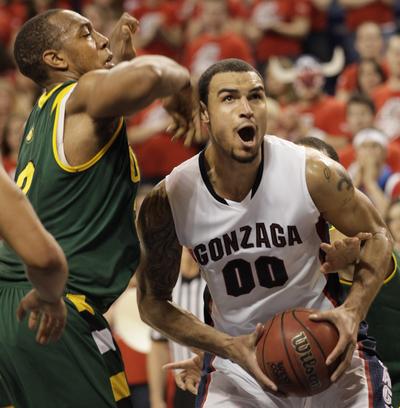 The Bulldogs’ Robert Sacre, who scored 13 points, drives past San Francisco’s Perris Blackwell during the second half.  (Associated Press)