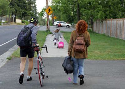 
Humberto Acevedo, left, and Jennifer Wilcox-Acevedo walk as daughter, Elena, 6, runs ahead to the bus stop Monday  in Bellevue, Wash. For the past seven months,  the family has lived without a car. Associated Press
 (Associated Press / The Spokesman-Review)