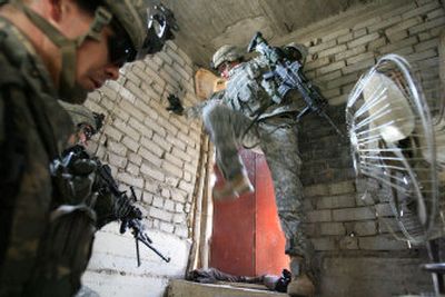 
U.S. Army Sgt. Brad Mojonnier, 30, of San Diego, kicks  open a locked door as Lightning Platoon soldiers from Fort Lewis, Wash., search for suspected kidnappers in a home in Mosul, Iraq, on Saturday. 
 (Associated Press / The Spokesman-Review)