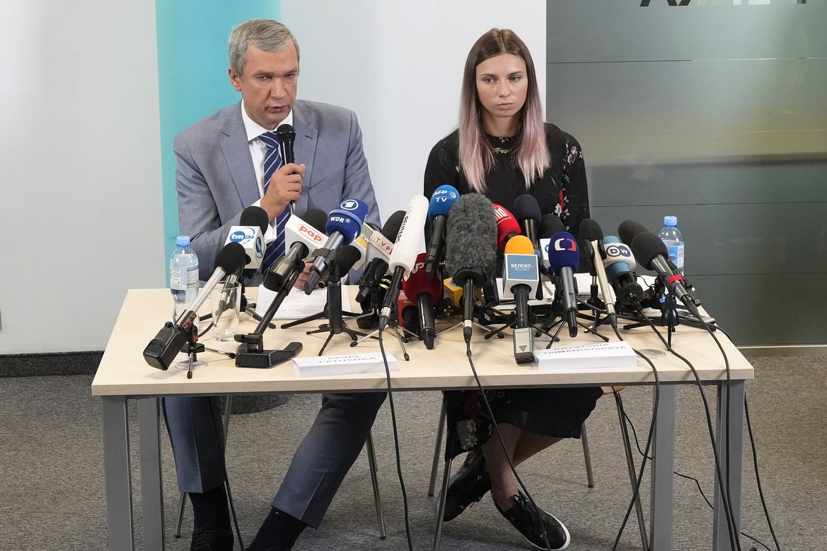 Belarusian dissident in Poland, Pavel Latushka, left, and Belarusian Olympic sprinter Krystsina Tsimanouskaya, right, who came to Poland fearing reprisals at home after criticizing her coaches at the Tokyo Games, talk to journalists in Warsaw, Poland, Thursday, Aug. 5, 2021.  (Czarek Sokolowski)