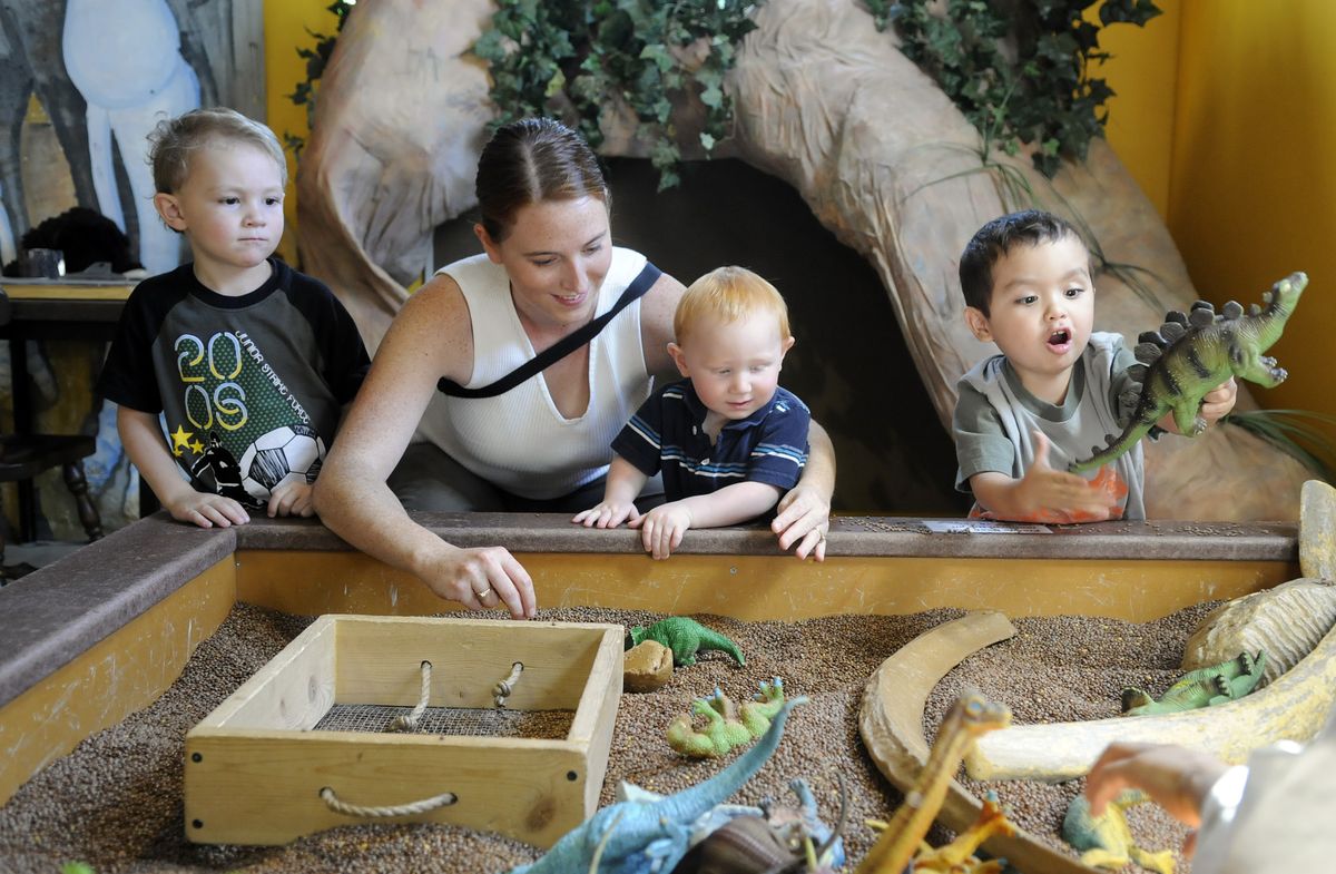 From left, Asa, VivAnne and Darius Fischer along with Benjamin Gomez dig around in the mammoth display at Palouse Discovery Science Center.  (Dan Pelle / The Spokesman-Review)