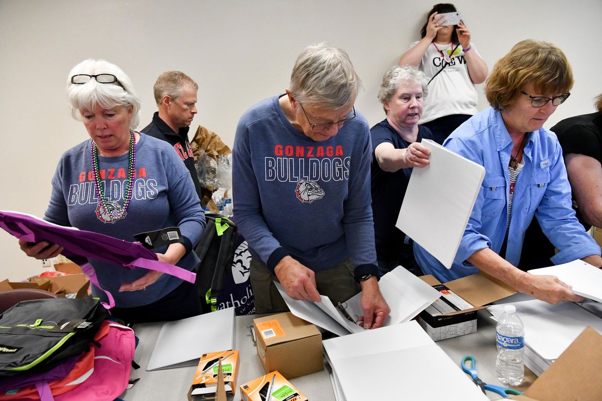 The scene is organized chaos as, from left: Patricia and John Habberstad, both self-described "rabid Gonzaga fans" work with Ruth Benage and Kathy Zimmerman, froming an assembly line to fill backpacks with learning materials for locals in need on Sunday, March 8, 2020, at Catholic Charities of Southern Nevada in Las Vegas. (Tyler Tjomsland / The Spokesman-Review)