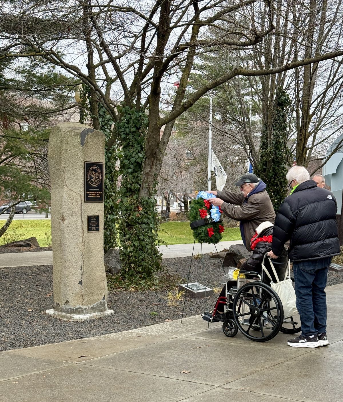 Vina Mikkelsen, wife of Pearl Harbor survivor Denis, watches as a member of her family adds a wreath to Spokane’s memorial monument to the attack.  (Caroline Saint James/THE SPOKESMAN-REVIEW)