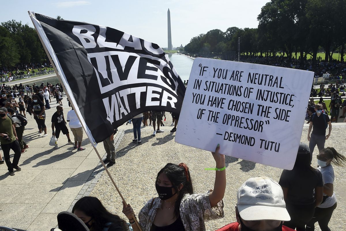 FILE - In this Aug. 28, 2020, file photo, demonstrators gather near the Lincoln Memorial as final preparations are made for the March on Washington, in Washington, on the 57th anniversary of the Rev. Martin Luther King Jr.