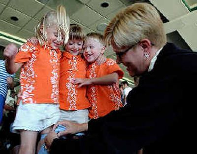 
Laura Masuda, of Edina, Minn., ties together the legs of her 4-year-old triplets, from left, Hannah, Grace and Tyler, in preparation for a four-legged race, one of the events at the Triplet Connection Convention in St. Louis. Laura Masuda, of Edina, Minn., ties together the legs of her 4-year-old triplets, from left, Hannah, Grace and Tyler, in preparation for a four-legged race, one of the events at the Triplet Connection Convention in St. Louis. 
 (Associated PressAssociated Press / The Spokesman-Review)