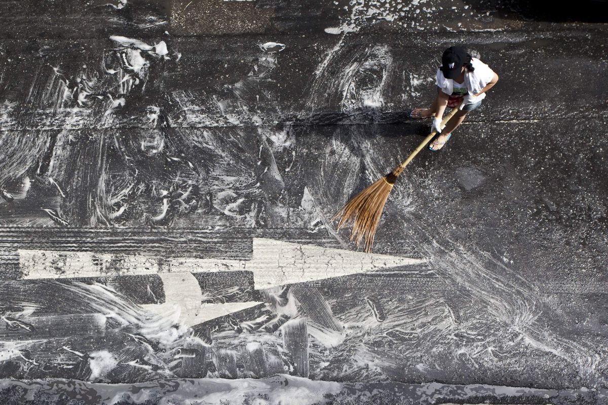 Workers scrub Silom Avenue  Sunday in Bangkok, Thailand. Thousands gathered in the Thai capital to begin the massive cleanup following the worst political violence in decades. Associated Press photos (Associated Press photos)