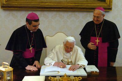 
Pope Benedict XVI signs the 