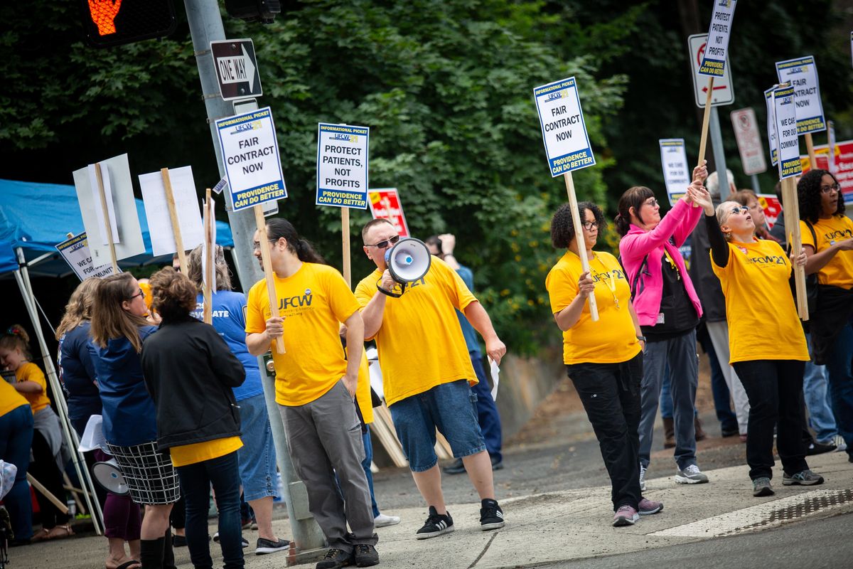 Joe Osborne, a bargaining member for negotiations of the United Food and Commercial Workers (UCFW) union helps lead a picket with Sacred Heart nurses and staff outside of Providence Sacred Heart Medical Center on June 27 in Spokane. Unionized Providence workers intend to strike starting on Jan. 14. (Libby Kamrowski / The Spokesman-Review)