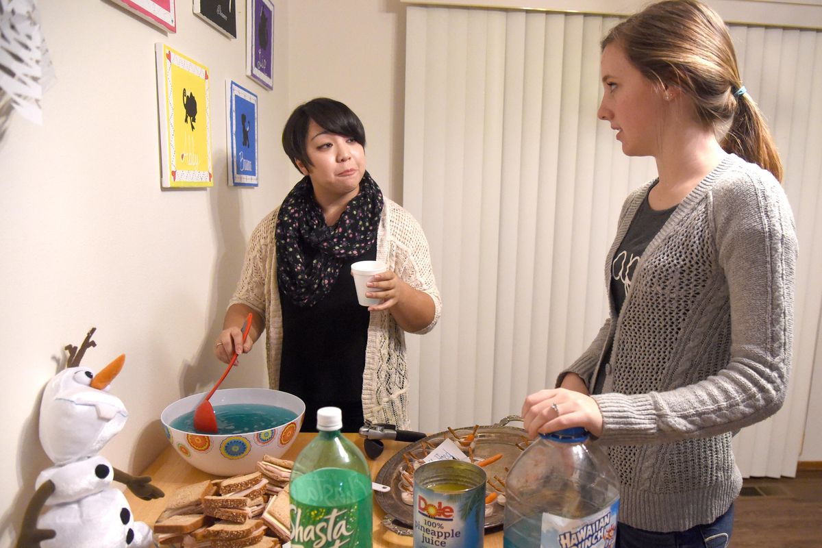Liz Richardson, left, and Sarah Fader, right, mix punch over a buffet table of sandwiches and appetizers before a showing of "Frozen" at the Disney Dinner House at Whitworth University, Thursday, Dec. 3, 2015. The four young women who live in the theme house on the campus of Whitworth University throw a monthly dinner and invite other students to attend a dinner of finger foods and a Disney movie. The home is one of several theme houses that are asked to host a monthly event in line with their house
