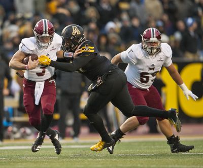 Troy quarterback Sawyer Smith  tries to break a tackle in a Nov. 24 game against Appalachian State in Boone, N.C. Smith had four touchdowns in the Trojans’ win over Buffalo in the Dollar General Bowl. (Walt Unks / AP)