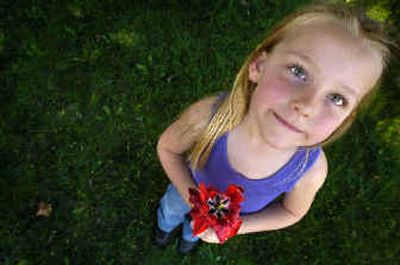 
Hailey Butler, 5, holds a bouquet of flowers she picked in front of her Spokane home Tuesday as temperatures reached the 70s. For today's weather forecast, see Page A2. 
 (Jed Conklin / The Spokesman-Review)