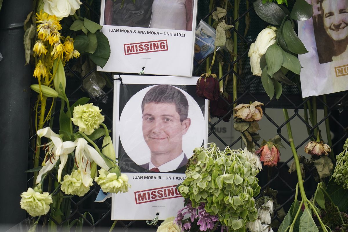 This June 29, 2021, photo shows a memorial wall for the victims of the Champlain Towers South building collapse in Surfside, Fla., with a photo of Juan Mora Jr. (Gerald Herbert)