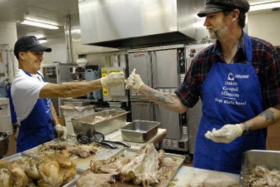 
Terry Sayles, left, and Walt Cookson break a turkey wishbone as they prepare dinner at Spokane's Union Gospel Mission Wednesday . The men participate in programs at the mission, along with working in the kitchen. They will help cook 40 turkeys for Thanksgiving.
 (Dan Pelle / The Spokesman-Review)
