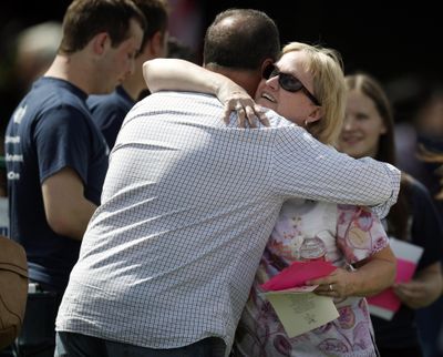 Attendees hug before a program for the victims of the massacre at Columbine High School 20 years ago Saturday, April 20, 2019, in Littleton, Colo. (David Zalubowski / Associated Press)