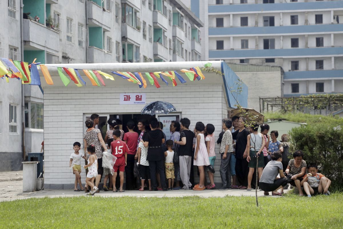 People line up at kiosk in Pyongyang, North Korea, last month. Street stalls are flourishing in Pyongyang and other North Korean cities. (Associated Press)