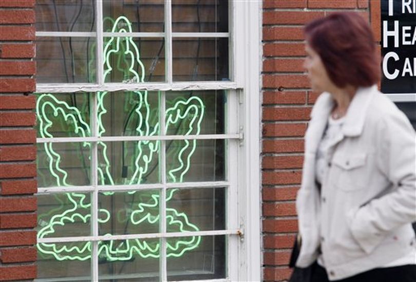 FILE - In this Tuesday Jan. 26, 2010 file photo, a pedestrian walks past a marijuana leaf neon sign advertising a medical marijuana provider along a street in the Sherman Oaks section of Los Angeles, Calif. Federal prosecutors have launched a crackdown on pot dispensaries in California, warning the stores that they must shut down in 45 days or face criminal charges and confiscation of their property even if they are operating legally under the state’s 15-year-old medical marijuana law. (AP Photo/Richard Vogel) ((AP Photo/Richard Vogel))
