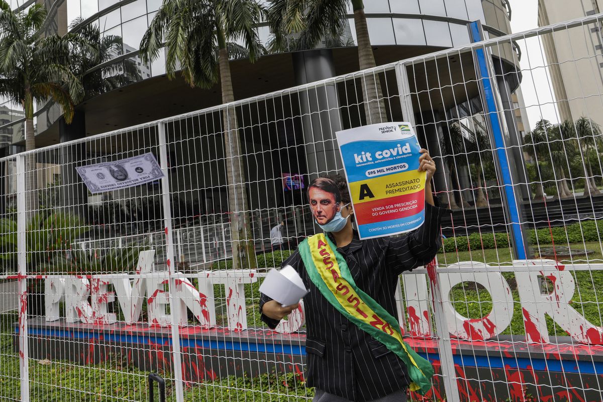 A demonstrator in a Brazilian President Jair Bolsonaro mask protests against the Prevent Senior health care company outside its headquarters in Sao Paulo, Brazil, Sept. 30, 2021. Whistleblowing doctors, through their lawyer, testified at the Senate last week that Prevent Senior enlisted participants to test unproven drugs without proper consent and forced doctors to toe the line on prescribing unproven drugs touted by President Jair Bolsonaro as part of a “COVID kit,” in the treatment of the new coronavirus.  (Marcelo Chello)