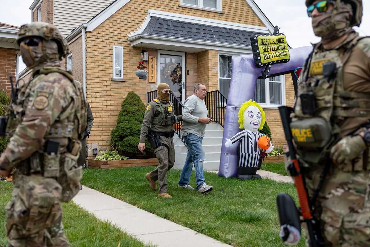 Border Patrol agents detain worker Krzysztof Klim while verifying his identification on Friday, Oct. 31, 2025, next to Halloween decorations outside a house in Chicago’s Edison Park neighborhood. Klim, originally from Poland and now a U.S. citizen, was briefly detained and then released.  (Brian Cassella/Chicago Tribune/TNS)