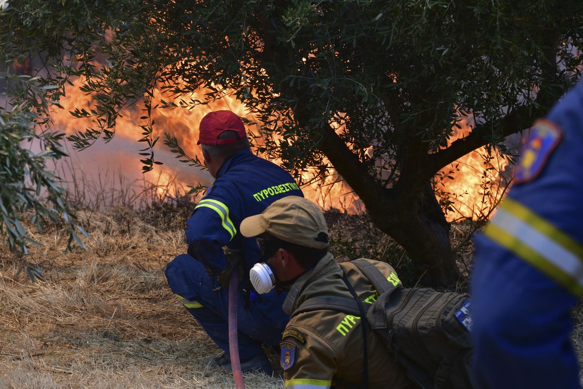 Firefighters try to extinguish a wildfire near Olympia town, western Greece, Thursday, Aug. 5, 2021. Wildfires rekindled outside Athens and forced more evacuations around southern Greece Thursday as weather conditions worsened and firefighters in a round-the-clock battle stopped the flames just outside the birthplace of the ancient Olympics.  (Giannis Spyrounis)