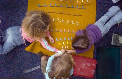 
Balboa Elementary Montessori students Louise Seely, left, Ashleigh Miller, center, and Kaitlyn Caprye work with beads to learn multiplication numbers.
 (Photos by CHRISTOPHER ANDERSON / The Spokesman-Review)