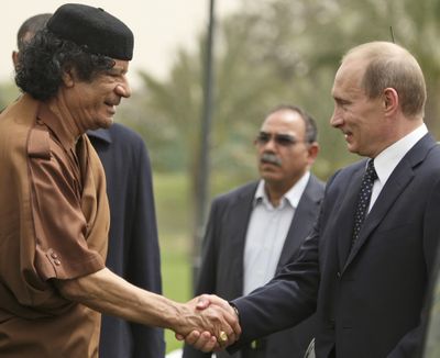 Libyan leader Moammar Gadhafi, left, and Russian President Vladimir Putin shake hands at the end of a two-day visit in Tripoli, Libya, in April.   (Associated Press / The Spokesman-Review)