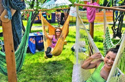 
Brandi Egnatz, left, relaxes in a hammock made by her company, Hangloose Hammocks, on Friday at ArtFest  while a customer  tries one out. The event continues through Sunday. 
 (Jed Conklin / The Spokesman-Review)
