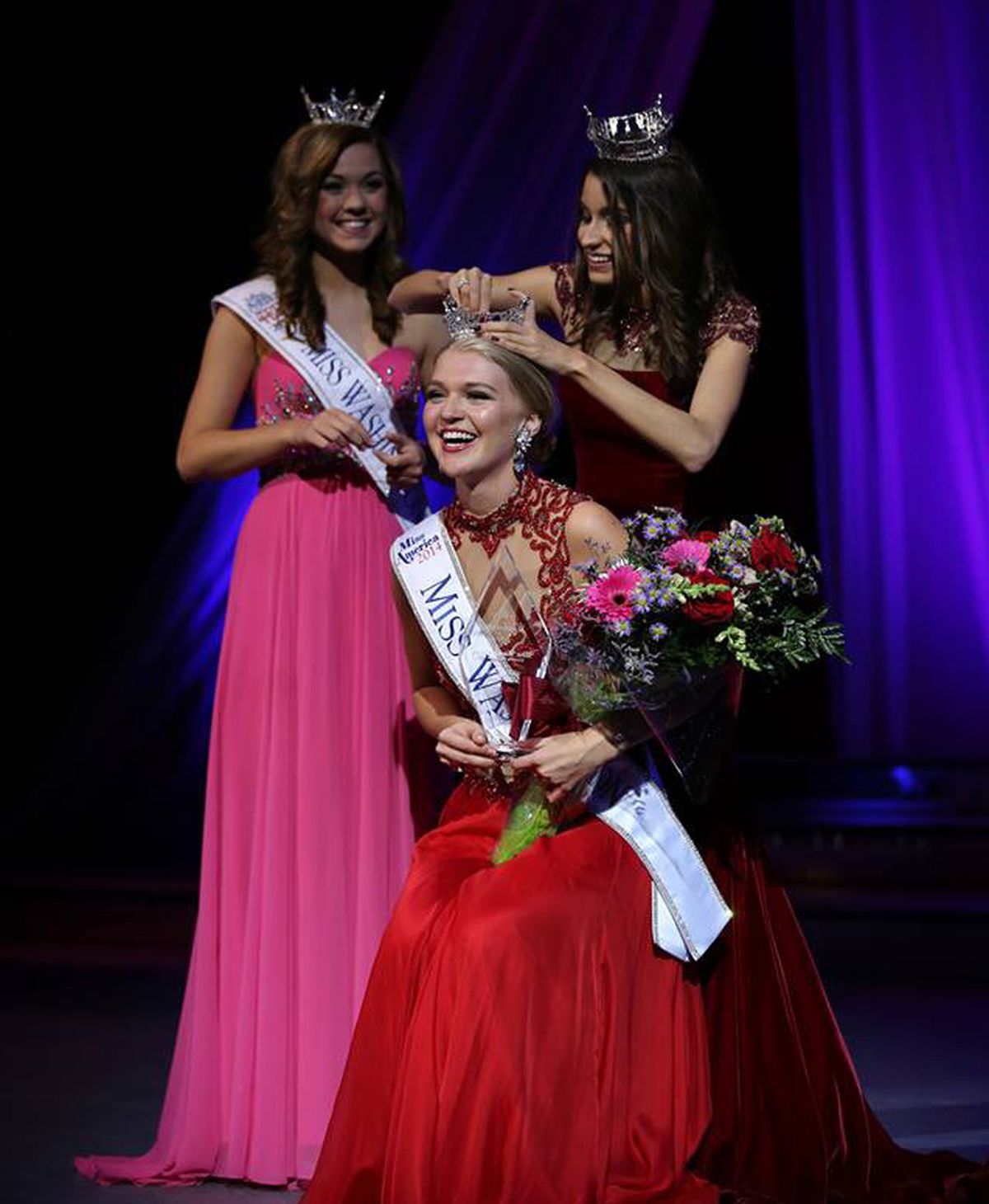 Miss Washington Outstanding Teen 2014 Tayler Plunkett, left, and Miss Washington winner 2013 Reina Almon crown Kailee Dunn as Miss Washington 2014.