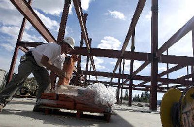 
Workers lift bags of mortar inside the steel skeleton of the Chinook medical building going up last spring in Coeur d'Alene. Building construction helped fuel job growth last year in Kootenai County.
 (File/ / The Spokesman-Review)