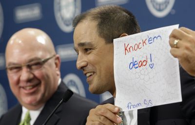 Don Wakamatsu has the support of his family (in this case a note from his daughter) as M’s GM Jack Zduriencik looks on.  (Associated Press / The Spokesman-Review)