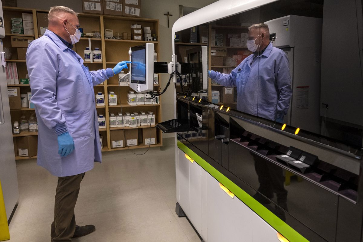 Rod McFadgen, a medical laboratory scientist, performs a COVID-19 (PCR) test on a batch of samples at the main chemistry lab in the basement of Providence Sacred Heart Medical Center on Thursday.  (Colin Mulvany/THE SPOKESMAN-REVIEW)