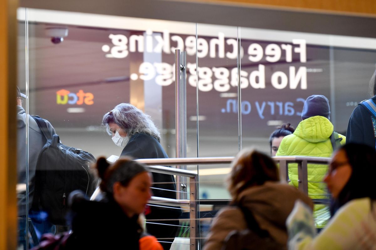A traveler is seen wearing a protective mask through a TSA security checkpoint on Sunday, March 1, 2020, at Spokane International Airport in Spokane, Wash. A few travelers were seen wearing surgical-style masks in the airport mid-day Sunday, in light of the recent Covid-19 outbreak. Experts say hand-washing is a far mare effective method for preventing transmission (Tyler Tjomsland / The Spokesman-Review)