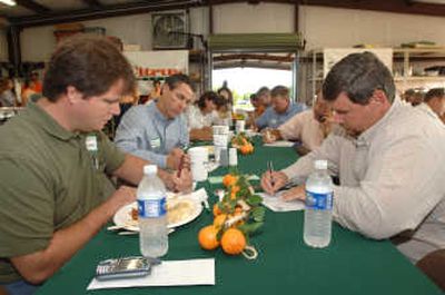 
Mark Wheeler, left, and Anthony Pascher, right, both of Wheeler Farms in Lake Placid, Fla., and area citrus farmers write down the numbers from a broadcast of the U.S. Department of Agriculture's initial 2007-08 citrus crop forecast Friday in Bartow, Fla.Associated Press
 (Associated Press / The Spokesman-Review)