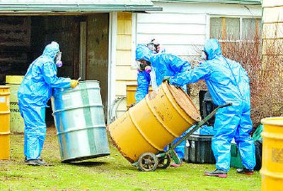 EPA contract workers on March 23, 2007, remove containers of toxic materials stored illegally in a garage on Loma Drive in Spokane. The owner of the house said her son was storing the materials. 
 (The Spokesman-Review)