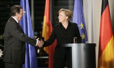 
Newly selected German Chancellor Angela Merkel, right, takes office Tuesday during a handing-over ceremony with outgoing Chancellor Gerhard Schroeder at the chancellery in Berlin. 
 (Associated Press / The Spokesman-Review)
