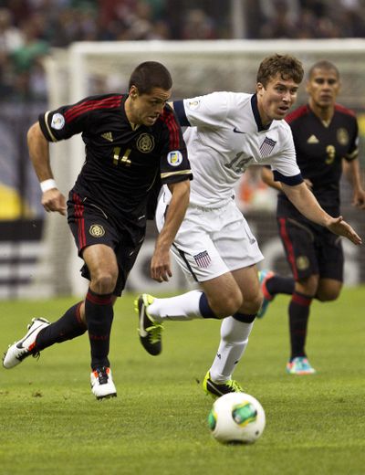Mexico's Javier Hernandez, left, and USA’s Matt Besler vie for ball. (Associated Press)
