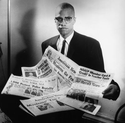 Portrait of human rights activist Malcolm X reading stories about himself in a pile of newspapers, circa 1963. (Three Lions/Hulton Archive/Getty Images/TNS)  (Three Lions/Hulton Archive/Getty Images North America/TNS)