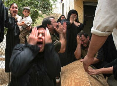 
Relatives of a 9-year-old boy wails over his coffin during his funeral Wednesday at their home near the scene of the suicide bombing that killed him in East Baghdad.
 (Associated Press / The Spokesman-Review)