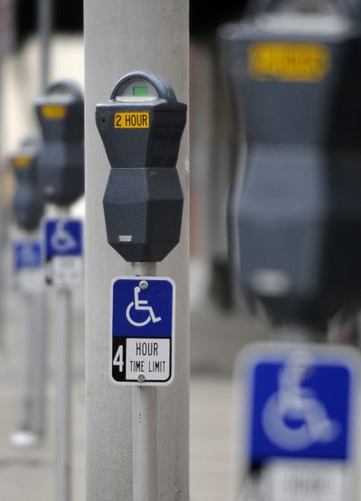 New blue handicapped parking signs have been added to parking meters along Sprague and First avenues between Post and Madison streets in downtown Spokane. The signs mean that disabled motorists, who can park at meters for free, can use the spaces for only four hours at a time.   (Dan Pelle / The Spokesman-Review)