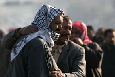 
Relatives mourn at the site where unidentified gunmen opened fire on a civilian car carrying five passengers, killing two and wounding three others, Tuesday in Baghdad. 
 (Associated Press / The Spokesman-Review)