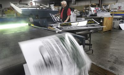 Duane Brown, right, owner of Advantage Printing, checks the results of a campaign sign run Wednesday at his Spokane shop. Bryan Brown operates a screen printing press in the background.   (CHRISTOPHER ANDERSON / The Spokesman-Review)