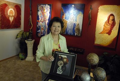Carmen Murray poses in the gallery of her Spokane Valley home. Her business card reads “Collage-Visionary-Contemporary.” She is also a psychic detective. (J. BART RAYNIAK / The Spokesman-Review)