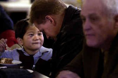 
Daniel Kang, 4, tells church member Daniel Oehler about his cake during the luncheon after Sunday morning services at the Korean Presbyterian Church. 
 (Liz Kishimoto / The Spokesman-Review)