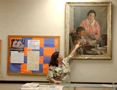 Robyn Sims, President of the Woodrow Wilson Middle School Home and School Board, points out damage that was done to the Catherine Morris Wright painting
