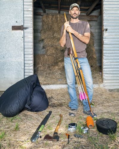 Clay Hayes, of Kendrick, Idaho, poses June 16 at his home with 10 belongings he was allowed to take on the television show “Alone.” Last fall, Hayes, an avid outdoorsman, bow maker and videographer, competed in and won the eighth season of “Alone,” which took place at Chilko Lake in British Columbia. Contestants were allowed to only bring 10 items with them and were challenged to survive in the wilderness by themselves for as long as possible. Hayes won $500,000.  (Pete Caster)
